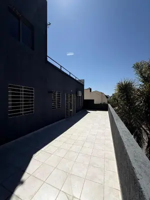 a walkway next to a building with palm trees at Puntasol vcpaz in Villa Carlos Paz