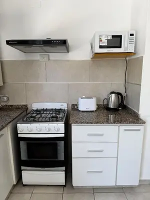 a kitchen with a stove and a microwave at Puntasol vcpaz in Villa Carlos Paz