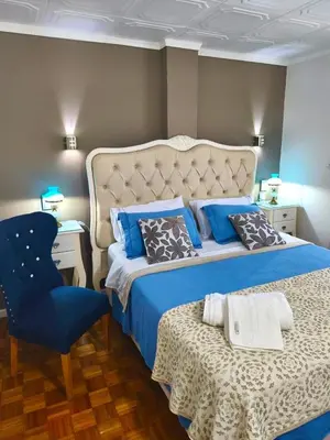a bedroom with a large bed and a chair at Acogedor Depto Boutique - Centro Histórico Córdoba in Cordoba