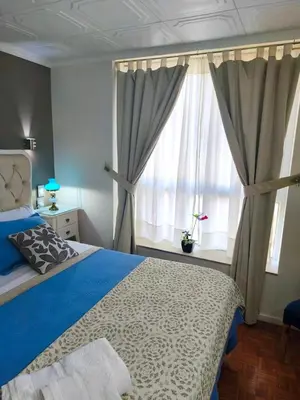 a bedroom with a blue bed and a window at Acogedor Depto Boutique - Centro Histórico Córdoba in Cordoba