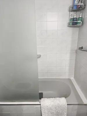 a bathroom with a tub and a shower with a towel at Acogedor Depto Boutique - Centro Histórico Córdoba in Cordoba