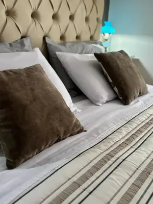 a bed with white pillows and brown pillows on it at Acogedor Depto Boutique - Centro Histórico Córdoba in Cordoba