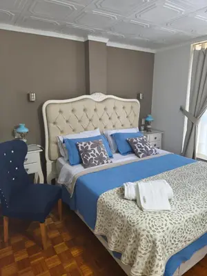 a bedroom with a large bed and a chair at Acogedor Depto Boutique - Centro Histórico Córdoba in Cordoba