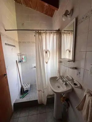 a bathroom with a sink and a shower with a mirror at Un escape mágico en el centro de la ciudad in Villa General Belgrano
