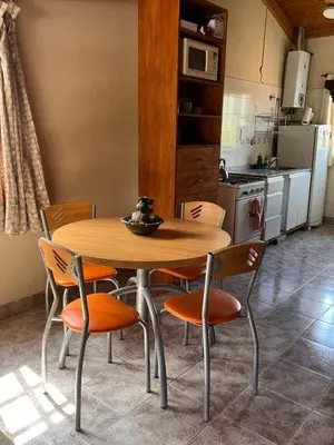 a kitchen with a wooden table and chairs at Un escape mágico en el centro de la ciudad in Villa General Belgrano