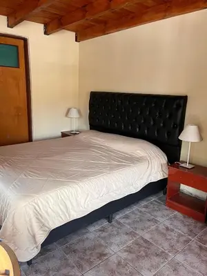 a bedroom with a large bed with a black headboard at Un escape mágico en el centro de la ciudad in Villa General Belgrano