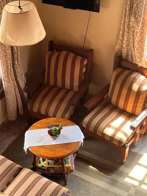 a living room with two chairs and a table at Un escape mágico en el centro de la ciudad in Villa General Belgrano