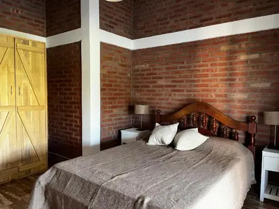 a bedroom with a bed and a brick wall at Complejo los Torres in Mina Clavero