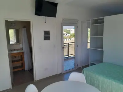 a bedroom with a bed and a view of a balcony at Lo de guada in Los Molles