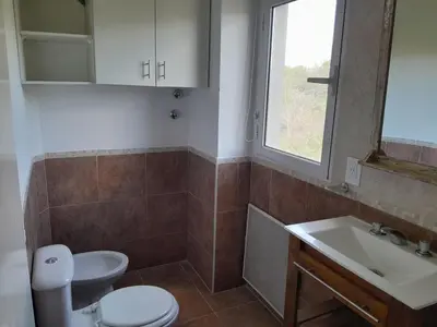 a bathroom with a toilet and a sink and a window at Lo de guada in Los Molles
