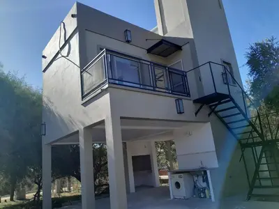 a white building with a staircase on the side of it at Lo de guada in Los Molles