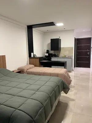 a hotel room with two beds and a kitchen at Centrico con Garage Monoambiente a Estrenar in Villa Dolores