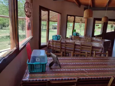 a dining room with a table and chairs and windows at La Margarita in Villa Ciudad Parque