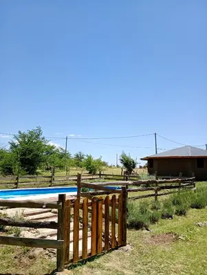 a wooden fence with a pool in a field at La Margarita in Villa Ciudad Parque