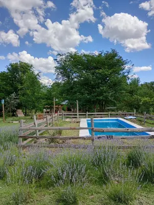 a fence around a swimming pool in a field at La Margarita in Villa Ciudad Parque