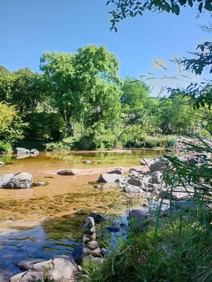 a river with some rocks in the water at La Margarita in Villa Ciudad Parque