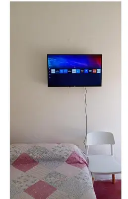 a flat screen tv hanging on a wall above a bed at El Dpto de Gabicito IV in Cordoba