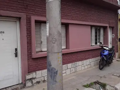 a blue motorcycle parked in front of a brick building at El Dpto de Gabicito IV in Cordoba