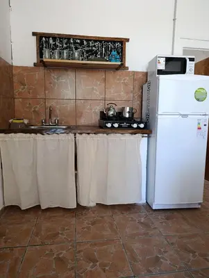 a kitchen with a white refrigerator and a sink at Lavanda y Romero Villa Yacanto de Calamuchita in Villa Yacanto