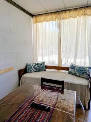 a room with a bed and a table and a window at Lavanda y Romero Villa Yacanto de Calamuchita in Villa Yacanto