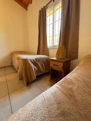 a room with two beds and a window at Entre Algarrobos - Cabañas con pileta y naturaleza in Villa de Las Rosas