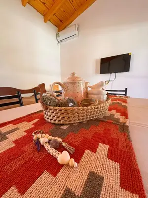 a table with a basket of items on a rug at Entre Algarrobos - Cabañas con pileta y naturaleza in Villa de Las Rosas