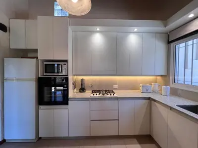 a kitchen with white cabinets and a white refrigerator at Casa de Campo a metros del rio en las Sierras de Cordoba in Atos Pampa