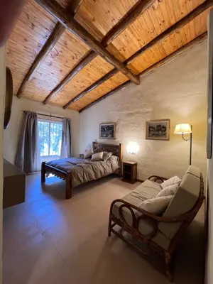 a bedroom with two beds and a wooden ceiling at Casa de Campo a metros del rio en las Sierras de Cordoba in Atos Pampa
