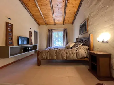a bedroom with a bed and a television in it at Casa de Campo a metros del rio en las Sierras de Cordoba in Atos Pampa