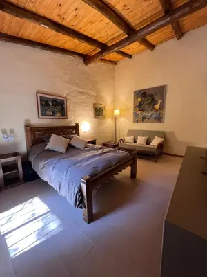 a bedroom with a large bed and a couch at Casa de Campo a metros del rio en las Sierras de Cordoba in Atos Pampa