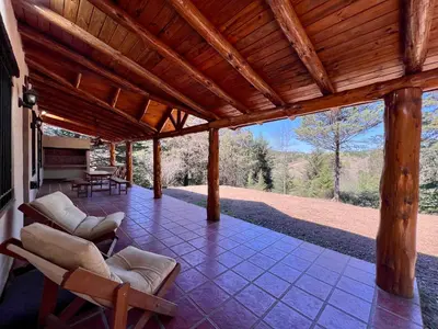 a porch with chairs and a wooden roof at Casa de Campo a metros del rio en las Sierras de Cordoba in Atos Pampa
