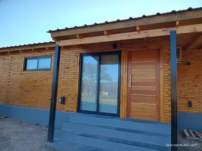 a house with a wooden door and stairs at Cabanas del Solar in Los Reartes