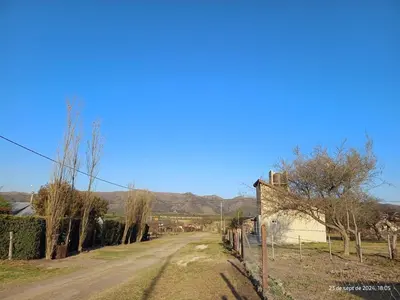 an empty road in a village with mountains in the background at Cabanas del Solar in Los Reartes