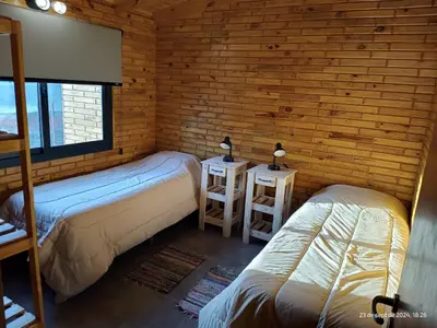 a room with two beds and two lamps on tables at Cabanas del Solar in Los Reartes