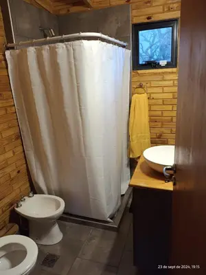 a bathroom with a toilet and a shower curtain at Cabanas del Solar in Los Reartes