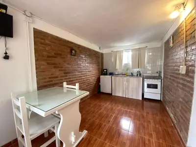 a kitchen with a table and a brick wall at Agosto 23 in Mina Clavero
