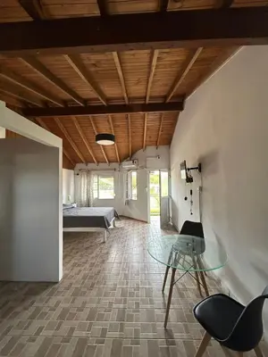a living room with a glass table and a bed at Agosto 23 in Mina Clavero