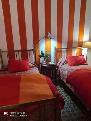 a bedroom with two beds and a striped wall at La Victoria descanso Cordobes in Cordoba