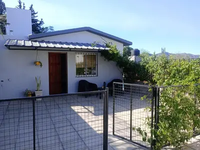 a white house with a fence in front of it at Monoambiente Atardeceres in Villa Carlos Paz