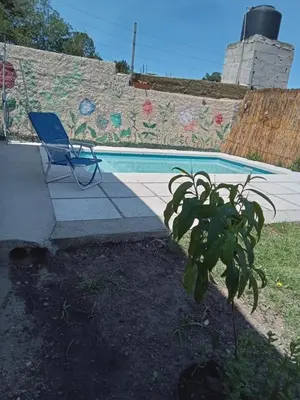 a blue chair sitting next to a swimming pool at Monoambiente Atardeceres in Villa Carlos Paz