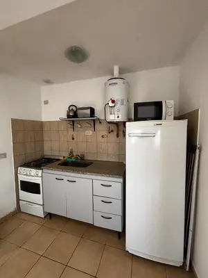 a kitchen with a white refrigerator and a sink at Monoambiente Atardeceres in Villa Carlos Paz
