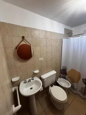 a bathroom with a sink and a toilet and a mirror at Monoambiente Atardeceres in Villa Carlos Paz