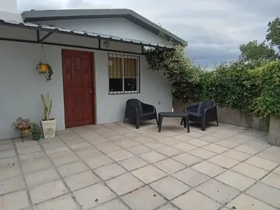 a patio with two chairs and a red door at Monoambiente Atardeceres in Villa Carlos Paz