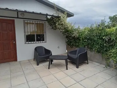 two chairs and a table in front of a house at Monoambiente Atardeceres in Villa Carlos Paz