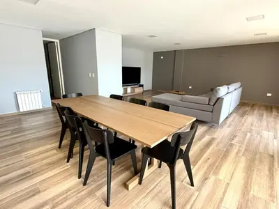a living room with a table and chairs and a couch at Alojamiento entero para 8 personas Belgrano Park in Cordoba