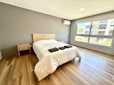 a bedroom with a bed and a large window at Alojamiento entero para 8 personas Belgrano Park in Cordoba