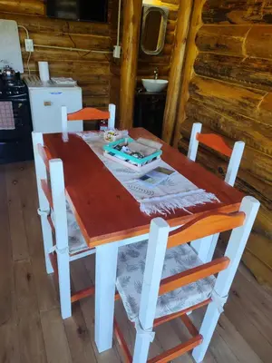 a wooden table and chairs in a cabin at Refugio Doña Josefa, cabaña de montaña La Cumbrecita in La Cumbrecita