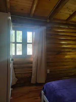a bedroom with a bed and a window at Refugio Doña Josefa, cabaña de montaña La Cumbrecita in La Cumbrecita