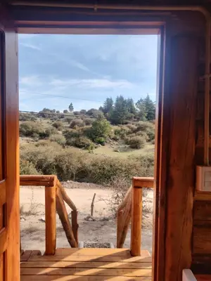 a door to a room with a view of a field at Refugio Doña Josefa, cabaña de montaña La Cumbrecita in La Cumbrecita