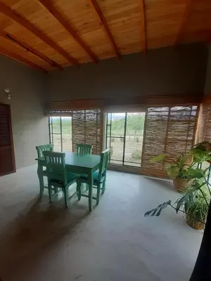 a dining room with a table and chairs and windows at Sonidos del Silencio in Las Rabonas